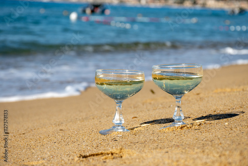 Summer time on French Riviera, two coupe glasses of champagne cremant sparkling wine on Pampelonne sandy beach near Saint-Tropez in sunny day, Var, vacation in France photo