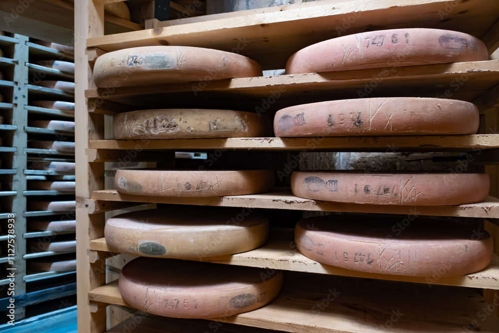 Aging rooms with shelves in cheese caves, central location for aging of wheels, rounds of Comte cheese from four months to several years made from unpasteurised cow milk, Jura, France Aging rooms with shelves in cheese caves, central location for aging of wheels, rounds of Comte cheese from four months to several years made from unpasteurised cow milk, Jura, France