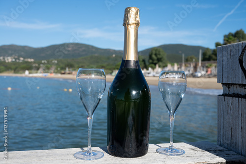 Summer time in Provence, two glasses of cold champagne cremant sparkling wine on famous Pampelonne sandy beach near Saint-Tropez in sunny day, Var department, France, beach club party photo