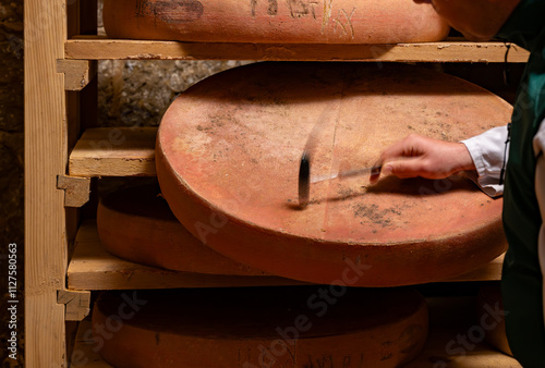 Cheese check in aging rooms with shelves in caves, central location for aging of wheels, rounds of Comte cheese from four months to several years made from unpasteurised cow milk, Jura, France photo