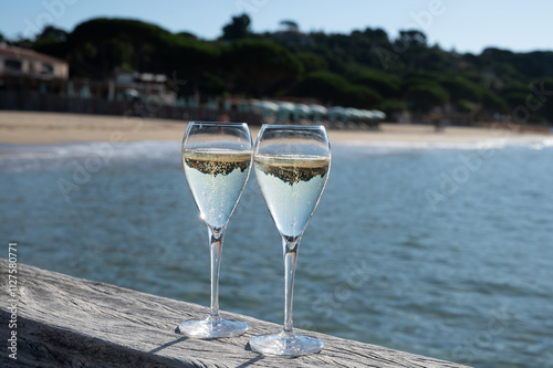 Summer time in Provence, two glasses of cold champagne cremant sparkling wine on famous Pampelonne sandy beach near Saint-Tropez in sunny day, Var department, France, beach club party photo