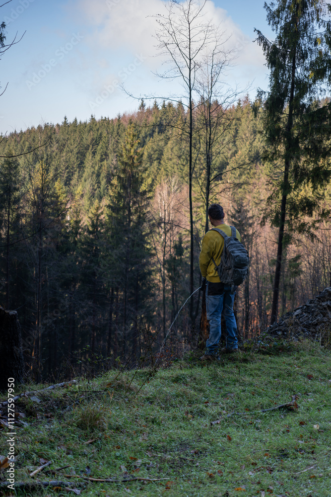 Male hiker with a backpack urinates in the forest.
Male hiker with a backpack urinates in the forest.