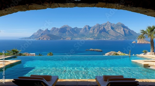 Majestic Oceanfront View with Infinity Pool Overlooking Stunning Mountains Across Clear Blue Waters at Luxurious Holiday Resort