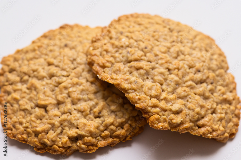 Group of oatmeal cookies on surface. And with background. Round cookie with sweetened oats and white cookie lying on a white background. A round cookie with a white background lies on lifestyle a.