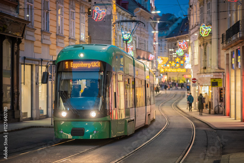 Green tram number 1 to Eggenberg in Graz city is driving on christmas decorated street in the centre. Picturesque colorful street with green tram photo