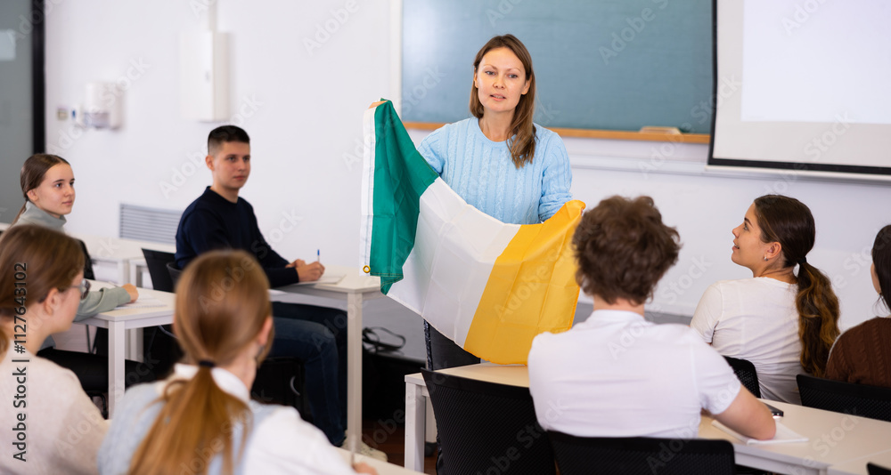 Obraz premium Adult female geography teacher tells students about the flag of Ireland