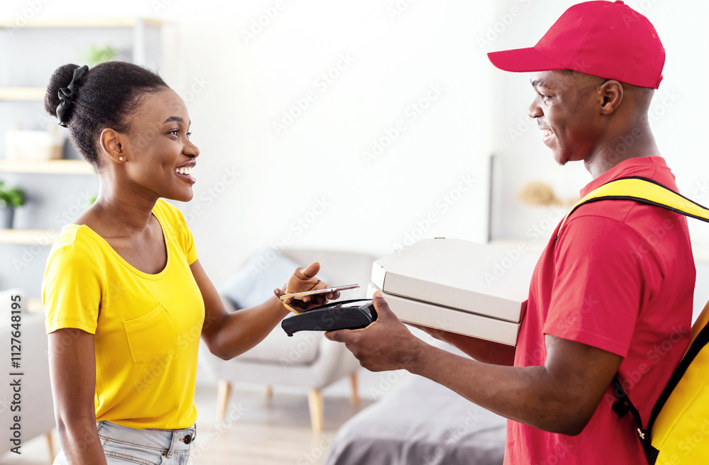Food Delivery. African American Female Paying Courier For Pizza Putting Mobile Phone To Payment Terminal Standing Indoors. Restaurant Delivering Service Concept. Selective Focus Food Delivery. African American Female Paying Courier For Pizza Putting Mobile Phone To Payment Terminal Standing Indoors. Restaurant Delivering Service Concept. Selective Focus