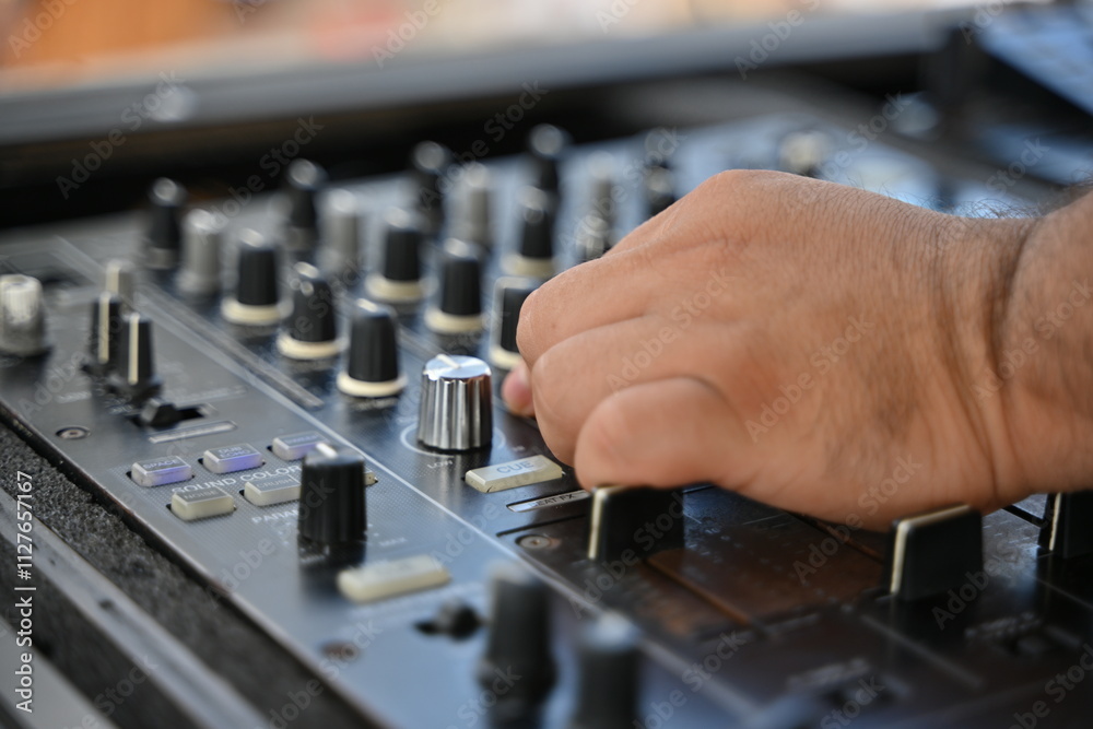 Un Dj mezclando música desde una consola de sonido Un Dj mezclando música desde una consola de sonido