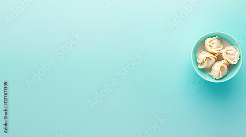 Delicious gyoza dumplings arranged in bowl on mint green background