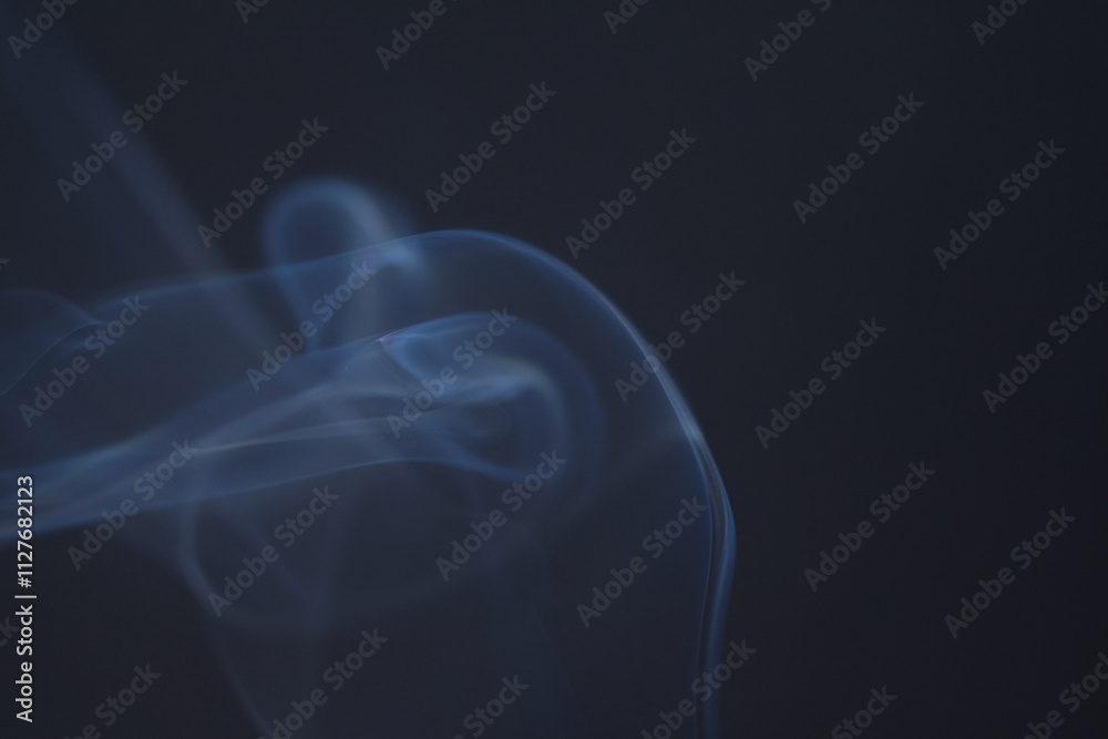 Close up of incense smoke as background. Smoke is the gaseous products of burning materials especially of organic origin made visible by the presence of small particles of carbon Close up of incense smoke as background. Smoke is the gaseous products of burning materials especially of organic origin made visible by the presence of small particles of carbon