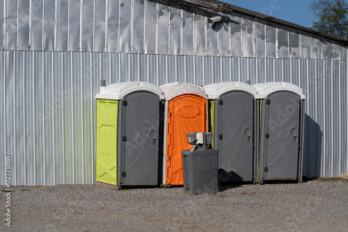 Portable rest rooms and a sanitary station outside a metal buildind photo