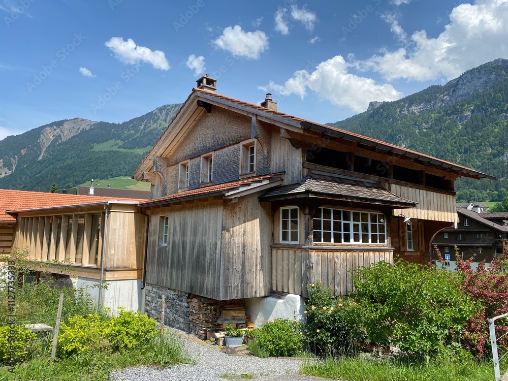 Fototapeta premium Traditional rural architecture and family livestock farms on the shores of Lake Lungern - Canton of Obwald, Switzerland (Traditionelle Architektur am Ufer des Lungernsees - Schweiz)