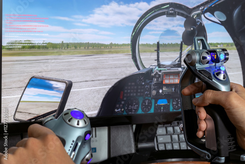 Man's hand holds joystick X52 in front of flight simulator screen