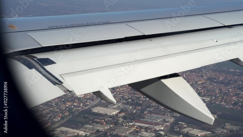 Top bird eye View from passenger porthole of beautiful landscape Flying airplane engine wing of plane fly on sunny cloudy day in winter. Transport, tourism, travel, flight, holidays vacation concept.