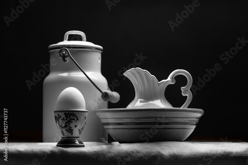 Still life of dairy products including an egg, milk jug and pitcher of cream in Black and white