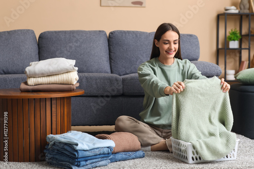 Young woman folding warm sw...