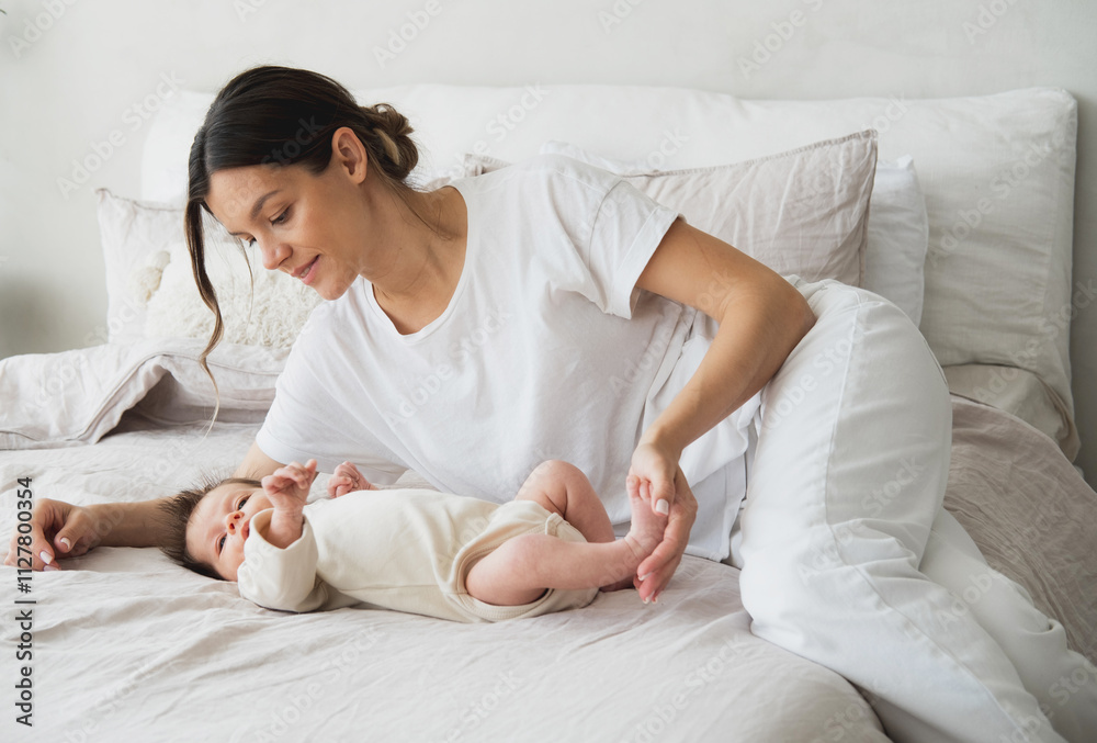 Portrait of a newborn baby with young mother on the bed. Portrait of a newborn baby with young mother on the bed.