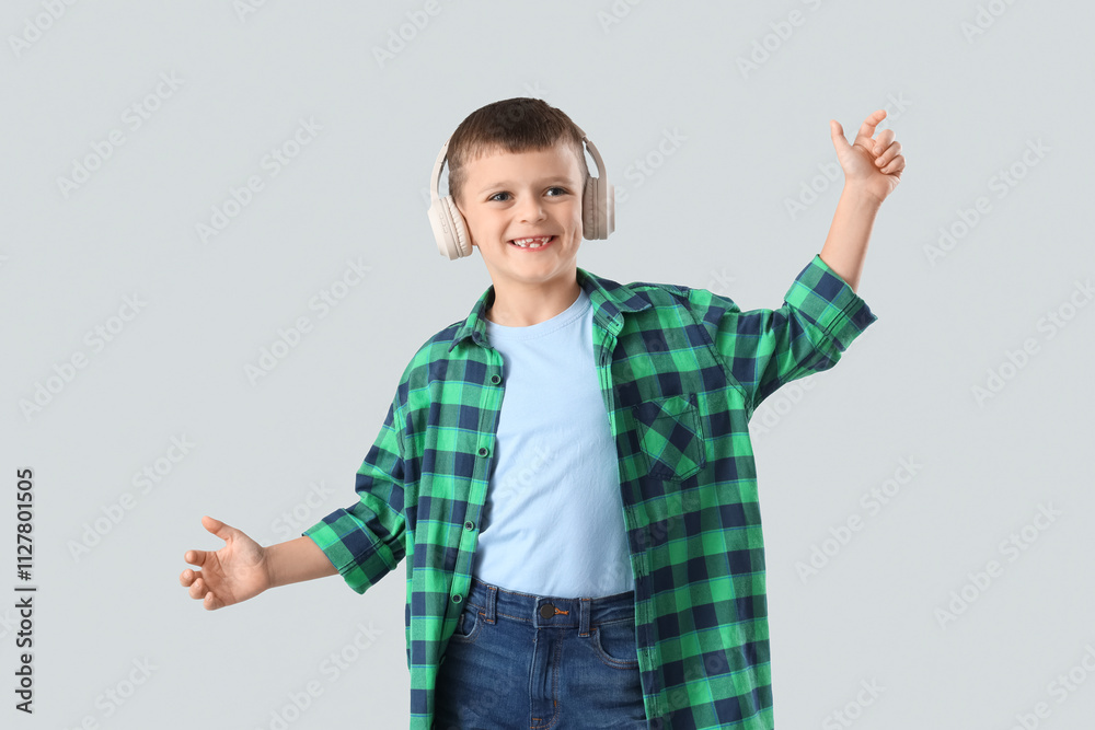 Cute little boy in headphones on light background Cute little boy in headphones on light background