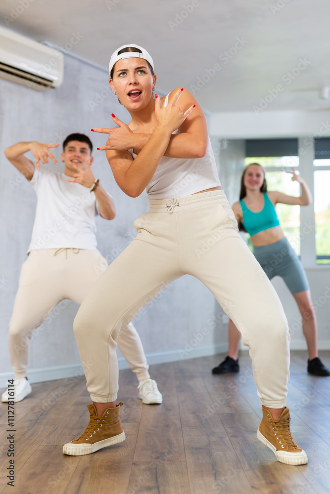 Group of young people learning modern dance movements at class together Group of young people learning modern dance movements at class together