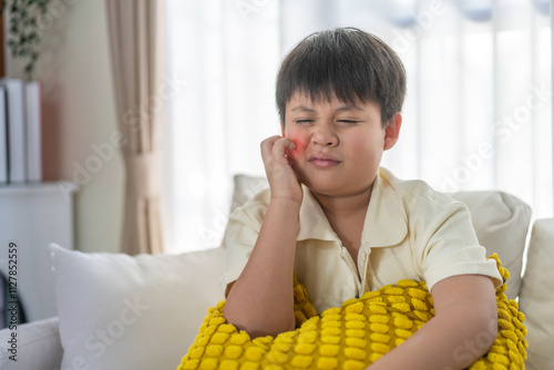 Young asian boy concerned expression itch or skin irritation, children allergy, particularly those related to skin care and health, childhood, health, skin care and medical attention daily life photo