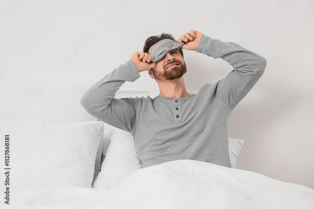 Morning of handsome man with sleeping mask lying in bedroom Morning of handsome man with sleeping mask lying in bedroom
