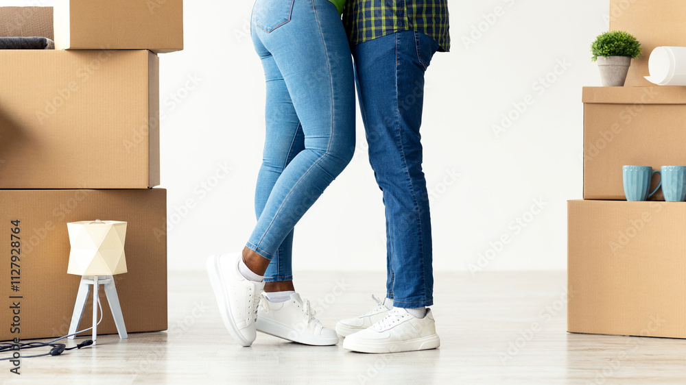 Closeup Shot Of Black Spouses Hugging Among Cardboard Boxes With Belongings In New Flat, Unrecognizable African American Spouses Standing In Their Apartment, Celebrating Relocation, Cropped Image