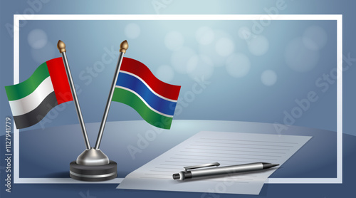 United Arab Emirate and Gambia National flags on small table with bokeh background, cooperative relationship
