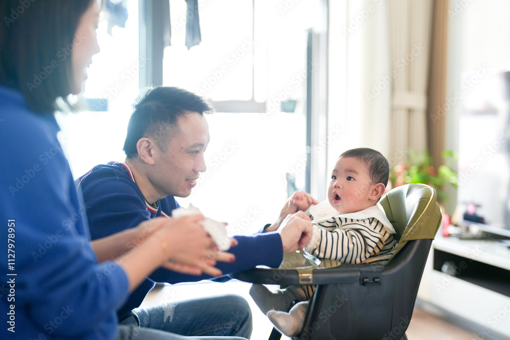 A 6-month-old boy sits in a chair with his mother and father from a Chinese family on a cold winter day in an apartment building in Pudong New District, Shanghai, China. A 6-month-old boy sits in a chair with his mother and father from a Chinese family on a cold winter day in an apartment building in Pudong New District, Shanghai, China.