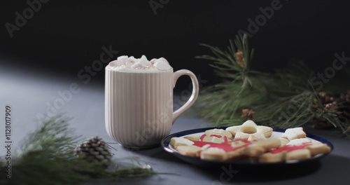 A cozy mug of hot chocolate sits beside holiday cookies