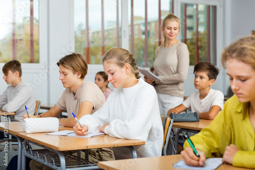 Student is sitting test and answer about task in the classroom.