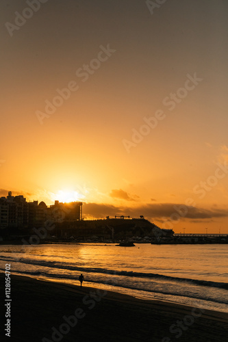 Obraz na płótnie People walking in te beach whit the Sunrise in the tourist city of Benidorm in Alicante, Spain in 2024. w salonie