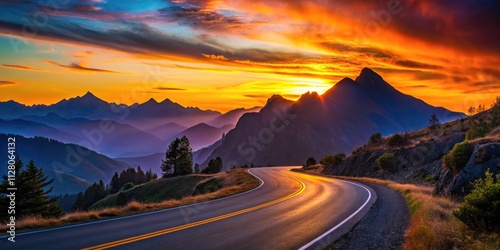 Sunset silhouettes mountain peaks as a remote road curves through a breathtaking, clear-skied landscape.