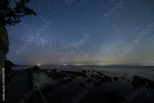 Obraz na płótnie 海沿いの遊歩道から見る水面の星と能登半島の星空 w salonie