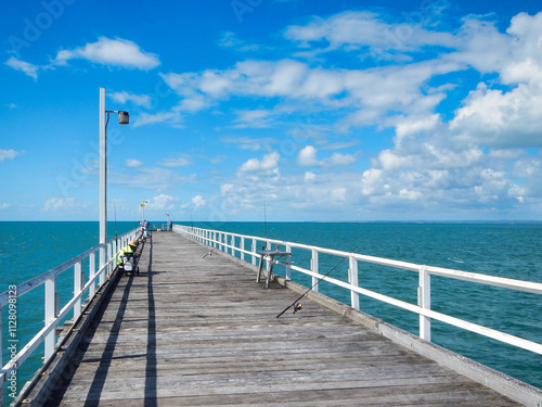 A beautiful pier featuring a white railing gracefully leading into the ocean Hervey Bay Fraser Australia