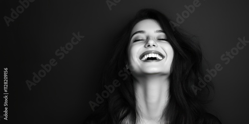 A joyful young woman is caught in a moment of laughter, showcasing a vibrant personality and genuine happiness, portrayed in a captivating black-and-white artistic style.