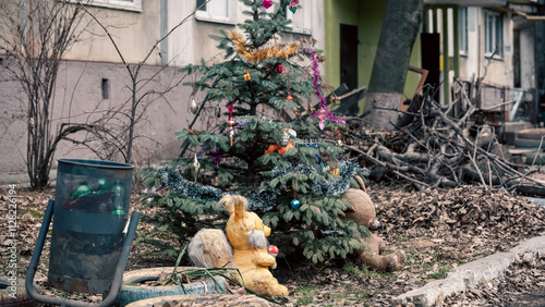 Christmas tree with toys near the house in the ruined city in Ukraine photo