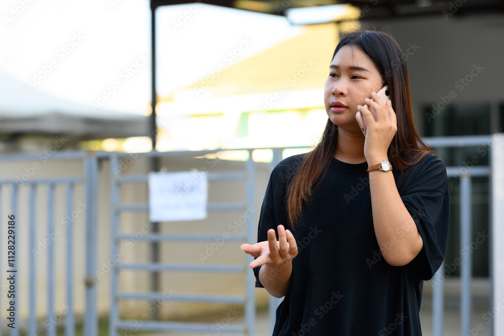 Young asian woman talking on mobile phone in a bright, urban environment Young asian woman talking on mobile phone in a bright, urban environment