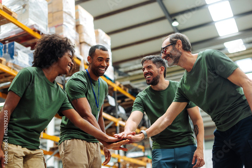 Warehouse workers joining hands for teamwork and success