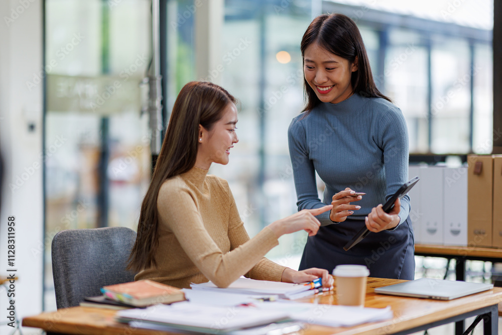 Fototapeta premium Two asian female creative agency casual meeting discussion working with laptop, analyze planning and financial statistics and investment market at office. 