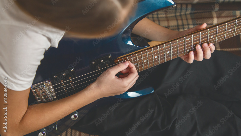 Fototapeta premium Girl playing electric guitar and practicing at home