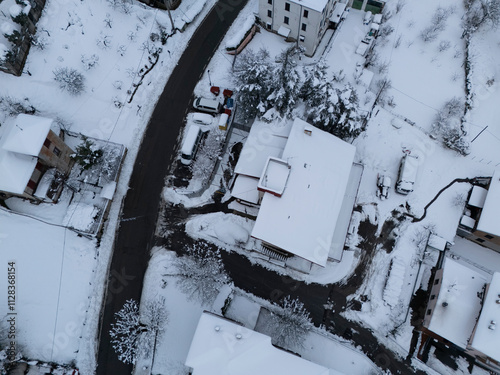 Fototapeta Naklejka Na Ścianę i Meble -  Snow covering the roofs of houses and streets in a small mountain village in italy during winter