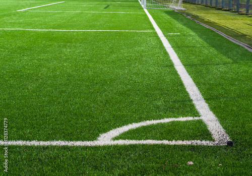 Green soccer field grass and white corner line .