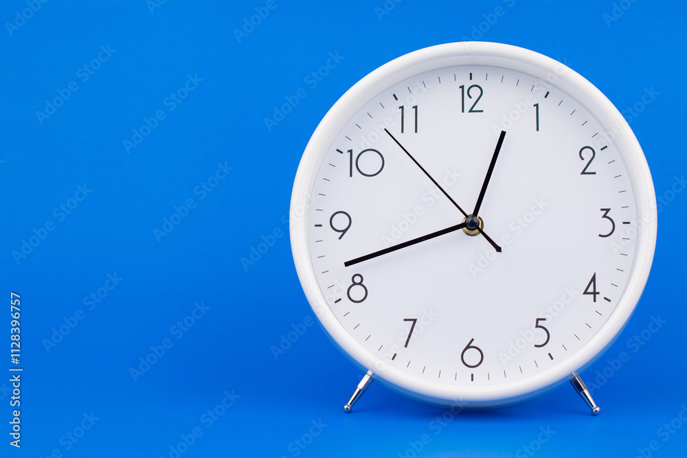 Clock telling time and working on time photo in studio on blue background Clock telling time and working on time photo in studio on blue background
