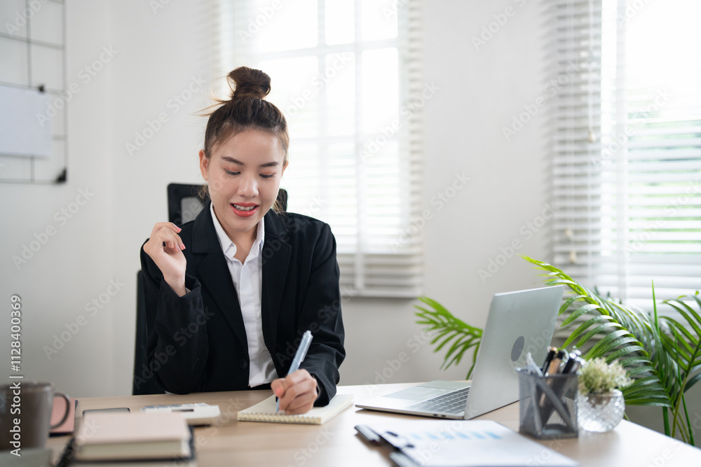 young asian woman working at her desk, writing notes. Businesswoman at her workplace. young asian woman working at her desk, writing notes. Businesswoman at her workplace.