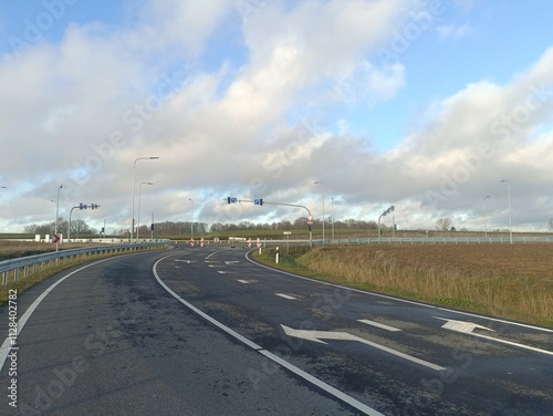 Aviacijos street in Siauliai. Empty street in suburbs. Sunny day with white and gray clouds in sky.  Aviacijos gatve Siauliuose. photo