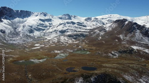 Chutkharo Lake on grassy plateau in high snowy Caucasus Mtns of Georgia photo