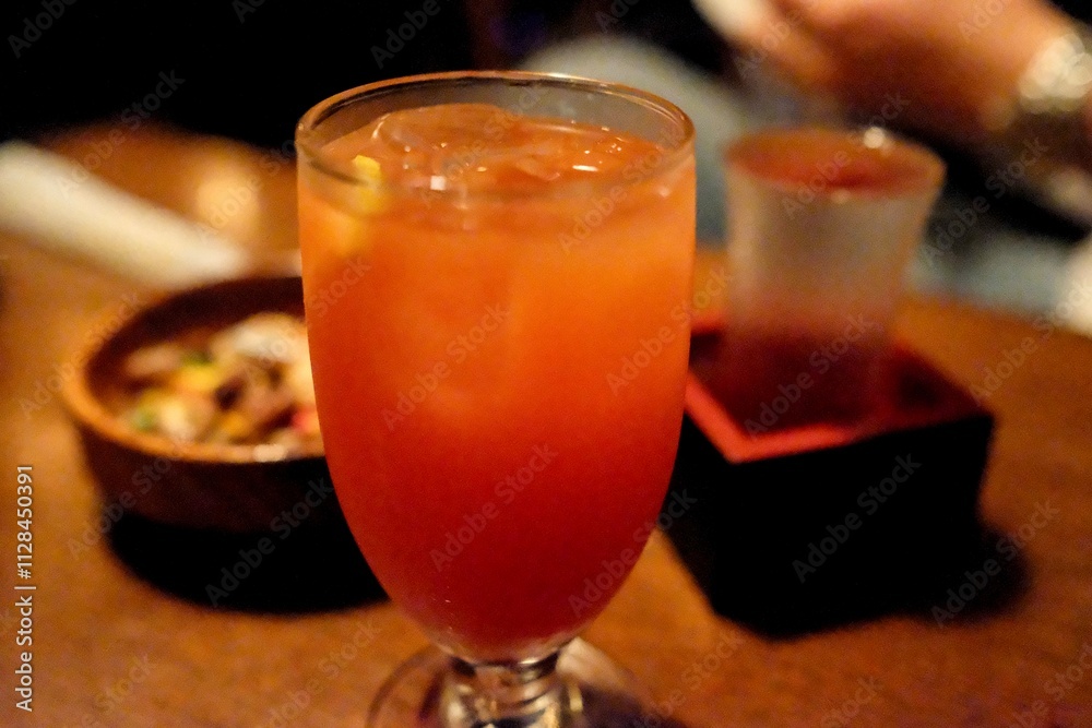 A tequila sunrise cocktail and glass of hot sake served with roasted nuts at Vagabond, a a jazz cafe and “drinking den” with live music in Shinjuku - Tokyo, Japan A tequila sunrise cocktail and glass of hot sake served with roasted nuts at Vagabond, a a jazz cafe and “drinking den” with live music in Shinjuku - Tokyo, Japan