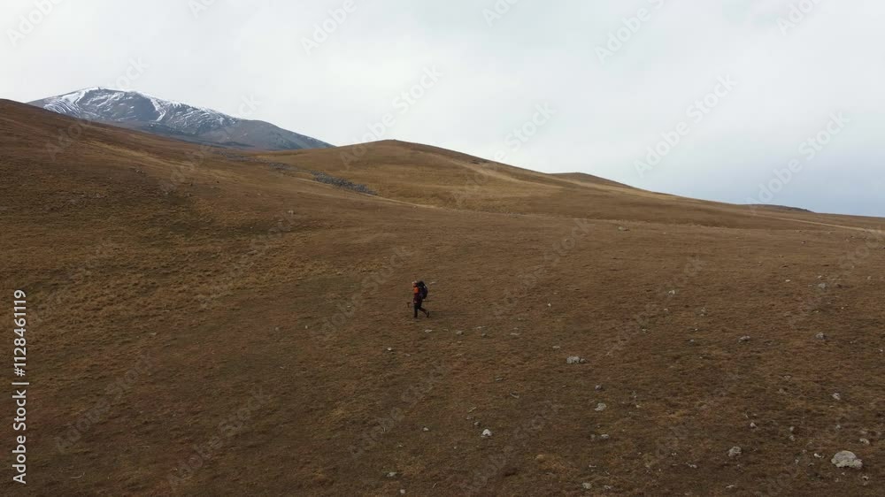 High angle: Backpacker on Transcaucasian Trial walks in open meadow High angle: Backpacker on Transcaucasian Trial walks in open meadow