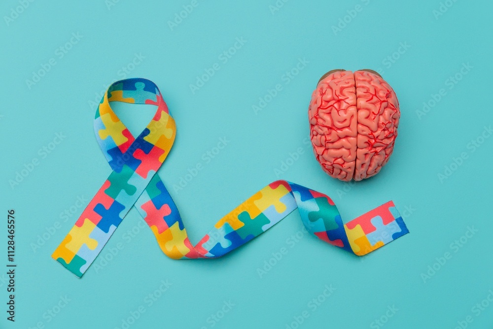 Fototapeta premium World Autism awareness and pride day. Anatomical model human brain with Puzzle pattern ribbon on blue background.