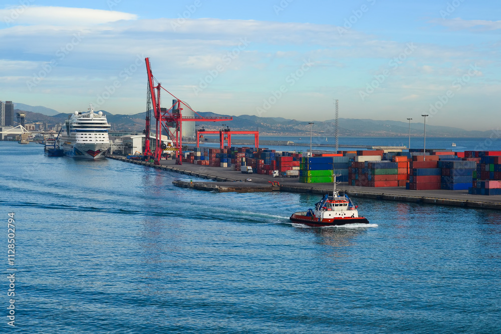 Fototapeta premium Tugboat navigating a busy port with cargo and cruise ship